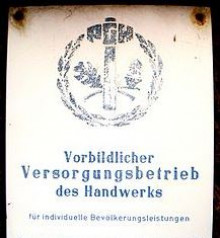 Bildinhalt: Ehrentafel an einer ausgezeichneten PGH zu DDR-Zeiten
